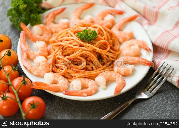 Spaghetti bolognese italian pasta with shrimp prawn served on white plate with tomato parsley in the restaurant italian food and menu concept / spaghetti seafood top view