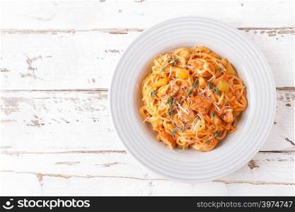 Spaghetti bolognese pasta with tomato sauce, vegetables and chicken meat on white wooden rustic background. Traditional italian food. Top view. Flat lay