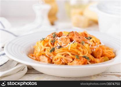 Spaghetti bolognese pasta with tomato sauce, vegetables and chicken meat on white wooden rustic background. Traditional italian food