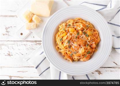 Spaghetti bolognese pasta with tomato sauce, vegetables and chicken meat on white wooden rustic background. Traditional italian food. Top view. Flat lay