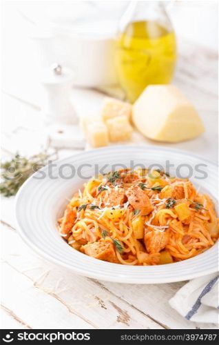 Spaghetti bolognese pasta with tomato sauce, vegetables and chicken meat on white wooden rustic background. Traditional italian food