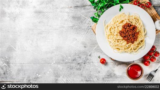Spaghetti bolognese with cherry tomatoes on the table. On a gray background. High quality photo. Spaghetti bolognese with cherry tomatoes on the table.