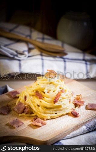spaghetti cabonara on wood table,shallow Depth of Field,Focus on bacon.. spaghetti cabonara. 