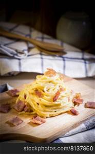 spaghetti cabonara on wood table,shallow Depth of Field,Focus on bacon.. spaghetti cabonara. 
