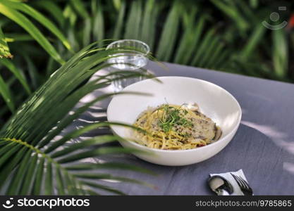 Spaghetti Carbonara and coconut under palm tree