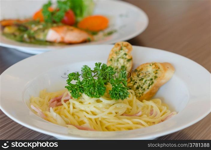 Spaghetti Carbonara . Spaghetti Carbonara with bacon and garlic bread on dish