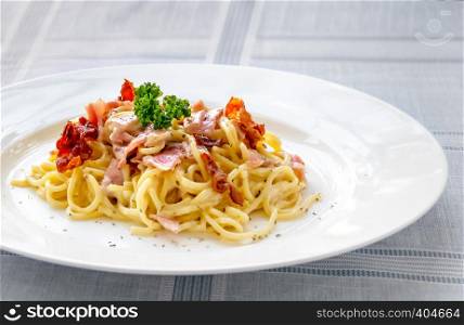 Spaghetti carbonara with bacon and cheese on white dish. Spaghetti carbonara with bacon