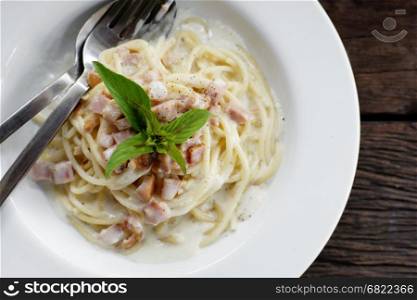 spaghetti carbonara with bacon on wooden table