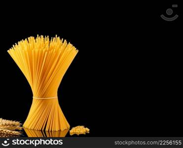 Spaghetti collection isolated on dark background with copy space. Whole grain pasta and spaghetti - shell on a dark mirrored table, ears of wheat nearby. Cooking concept, close-up