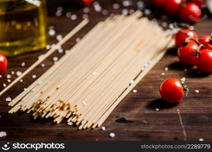 Spaghetti dry with cherry tomatoes. On a wooden background. High quality photo. Spaghetti dry with cherry tomatoes.