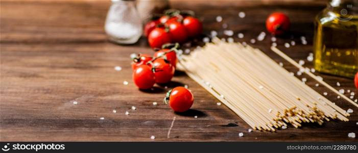 Spaghetti dry with cherry tomatoes. On a wooden background. High quality photo. Spaghetti dry with cherry tomatoes.