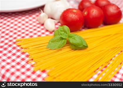 Spaghetti, Garlic, Basil and Tomatoes on Table - shallow depth of field