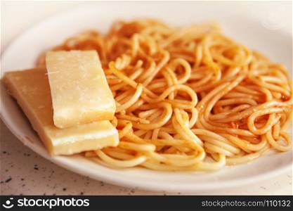 Spaghetti in tomato sauce with pieces of Parmesan cheese