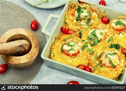 Spaghetti nests baked with meatballs and cheese in oven dish. Stuffed spaghetti nest appetizers