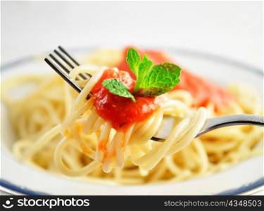 spaghetti on a fork with tomato sauce