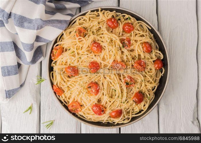 Spaghetti pasta with tomatoes and parsley on wooden table