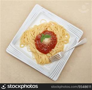 Spaghetti with a herb-flavoured tomato sauce, a traditional Italian dish known as Spaghetti Pomodoro, served with grated parmesan and a sprig of basil
