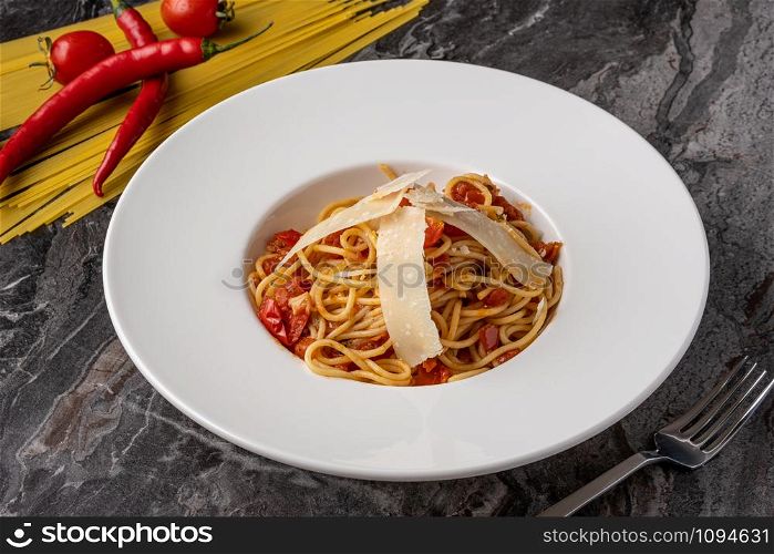 Spaghetti with a spicy sauce, chili pepper and grated parmesan cheese. spaghetti with parmesan