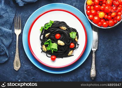 spaghetti with black mussels. plate of spaghetti with black mussels and tomatoes