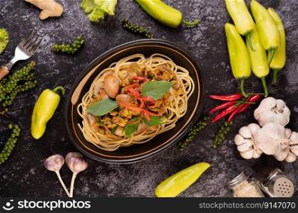Spaghetti with Clams in a Black Plate with Chilies Fresh garlic and pepper.