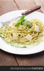 Spaghetti with green pesto and parmesan on the plate