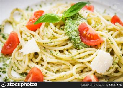 Spaghetti with green pesto, parmesan and cherry tomatoes