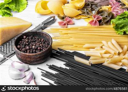 spaghetti with ingredients for cooking pasta. Large selection of uncooked spaghetti and macaroni on the kitchen table with ingredients