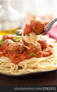 spaghetti with meatballs in tomato sauce on fork