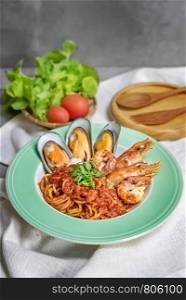 Spaghetti with seafood in tomato sauce on a plate. Spaghetti with seafood