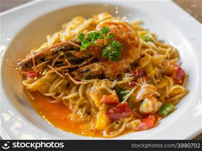 spaghetti with tiger prawn sauteed with shrimp oil in a plate