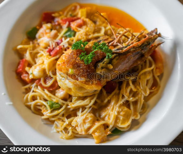 spaghetti with tiger prawn sauteed with shrimp oil in a plate