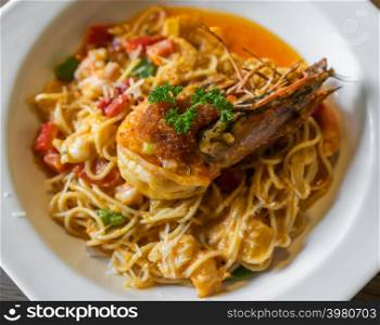 spaghetti with tiger prawn sauteed with shrimp oil in a plate