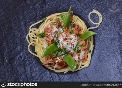 spaghetti with tomato sauce on a black plate