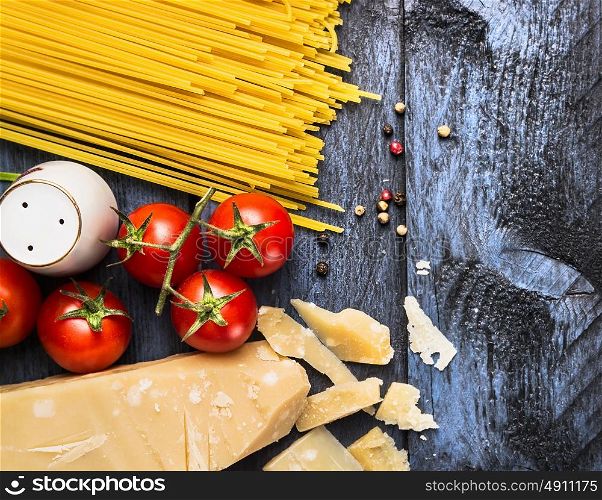 Spaghetti with tomatoes and parmesan on blue wooden background, top view, copy space