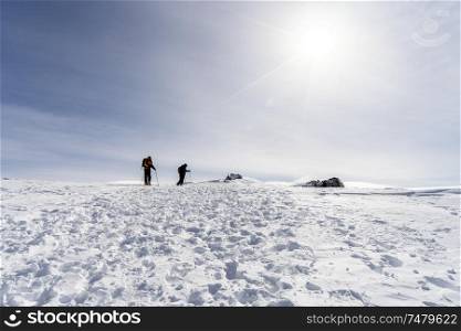 Spain, Andalusia, Granada. Ski resort of Sierra Nevada in winter, full of snow, with unrecognizable people doing cross-country skiing. Travel and sports concepts.. People doing cross-country skiing in Sierra Nevada