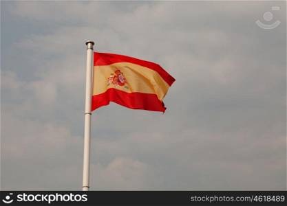 Spain flag waving on a mast with sky background