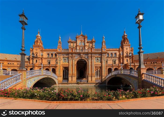 Spain Square or Plaza de Espana in Seville in the sunny summer day, Andalusia, Spain. Flower beds, bridges and channel in the foreground