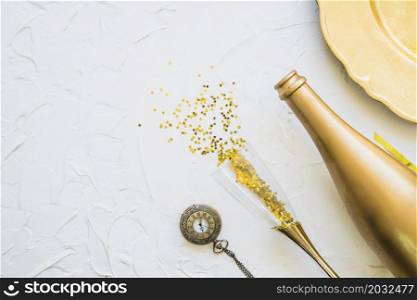 spangles scattered from glass with bottle