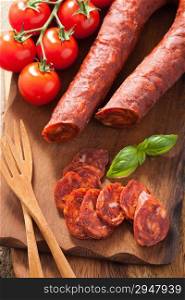 spanish chorizo sausage with basil on chopping board