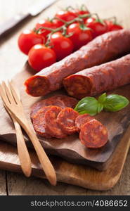 spanish chorizo sausage with basil on chopping board