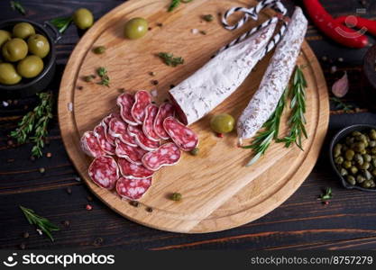 Spanish fuet salami sausageon wooden cutting board at domestic kitchen.. Spanish fuet salami sausageon wooden cutting board at domestic kitchen