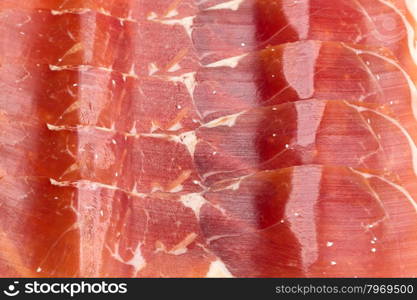 Spanish jamon, dry-cured ham thin slicing for background. Top view
