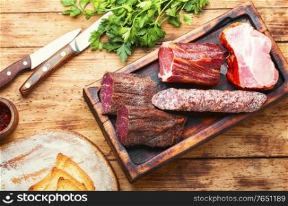 Spanish meat platter.Cured meat and sausages on cutting board. Chopping board of cured meat