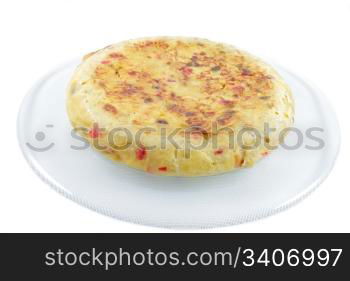 Spanish omelette made a??a??with potatoes, eggs, onion, green and red peppers, salt and olive oil, horizontal format with a white background isolated