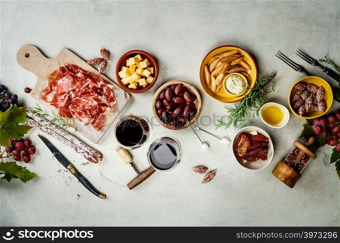 Spanish tapas , food border background overhead view. Wine and tapas on concrete background, top view