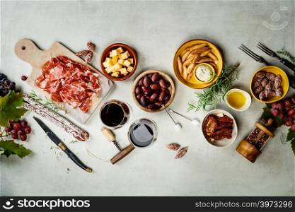 Spanish tapas , food border background overhead view. Wine and tapas on concrete background, top view