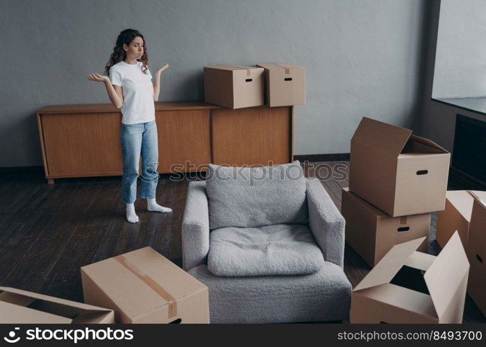 Spanish woman feels hard to move alone. Young lady is exhausted with boxes packing. Pretty girl in new apartment. Annoyed young lady has problem. Delivery service ordering concept.. Spanish woman feels hard to move alone exhausted with boxes packing. Delivery service ordering.