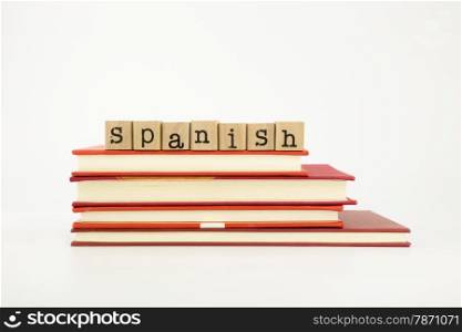 spanish word on wood stamps stack on books, language and academic concept