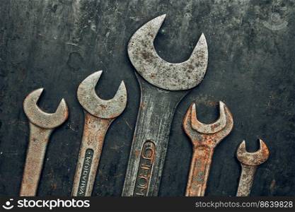 Spanners on steel surface. Old rusty wrenches for maintenance. Mechanic hardware tools to fix. Technical tools background with copy space