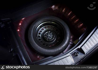 Spare wheel in a car, automotive part concept.